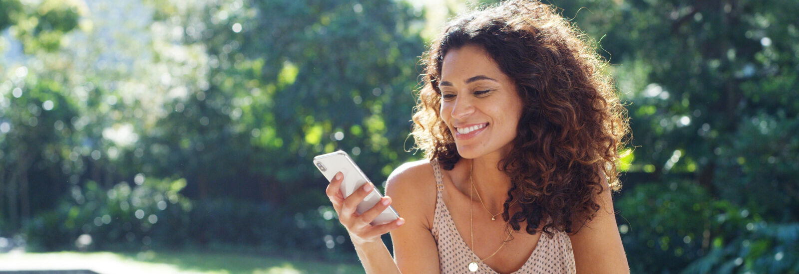 A woman using a smartphone and sitting outside